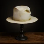 Front view of beige Memento custom fedora hat with distressed finish and stitched quote patch