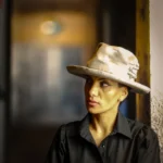 Woman wearing gray Memento fedora hat, side view, soft light, elegant minimalist outfit