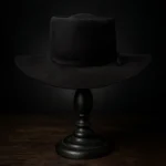 Front view of the handcrafted black felt replica hat inspired by Sam Chisolm, portrayed by Denzel Washington in The Magnificent Seven, displayed on a wooden stand.