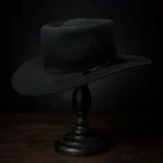 Side view of the handcrafted black felt replica hat inspired by Sam Chisolm, played by Denzel Washington in The Magnificent Seven, displayed on a wooden stand.